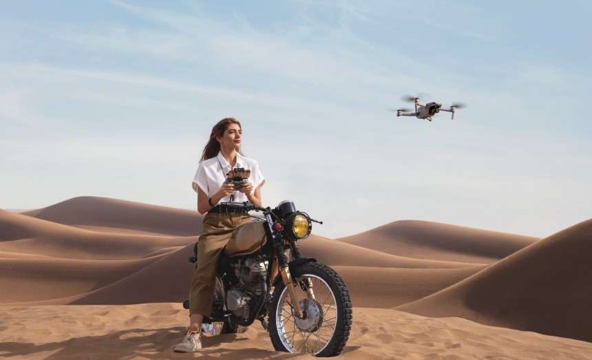 kobieta na motorze w pustyni pilotująca dronem DJI Air 2